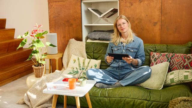 Vrouw zit op de sofa met een tablet